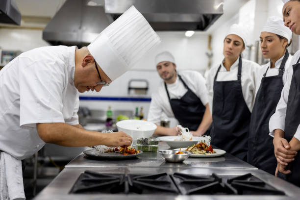 istock Chef teaching students how to serve a plate in a cooking class 2048177041