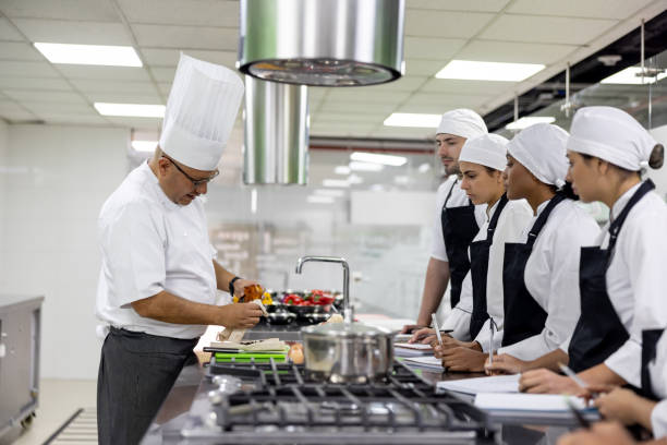 istock Chef teaching a group of students how to peel a pepper 2048177063