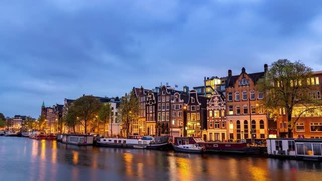 Amsterdam Netherlands time lapse city skyline day to night at canal waterfront