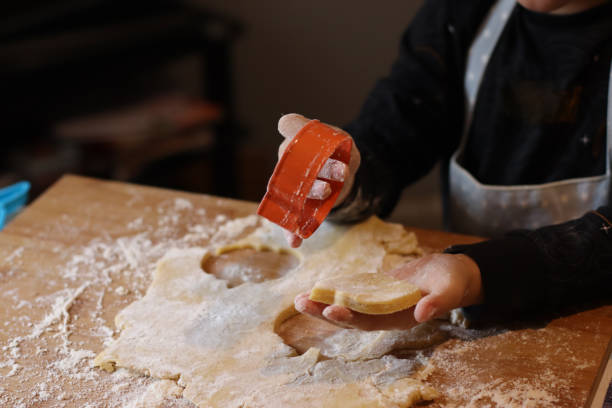 istock Child making fancy biscuits on a wooden board at home. 2048227067