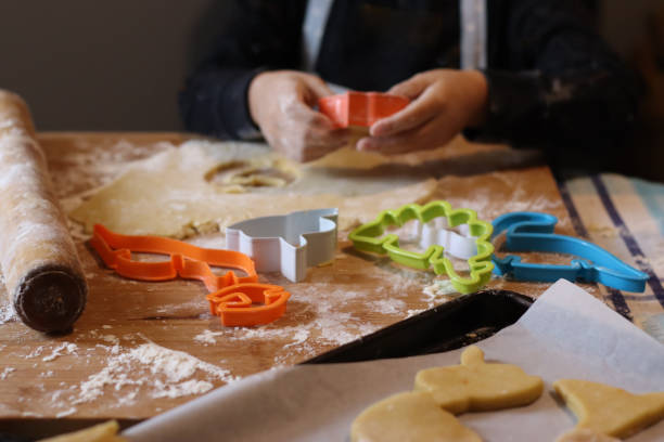 istock Child making fancy biscuits on a wooden board at home. 2048230207