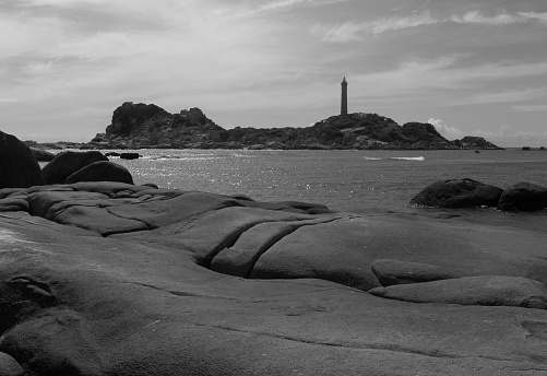 Sambro Island Lighthouse is reflected in a large puddle.  Built in 1758 it is the oldest operating lighthouse in North America.