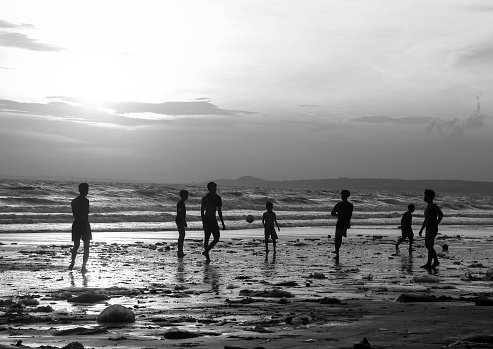 Young men playing soccer on the beach at sunset, Binh Thuan province