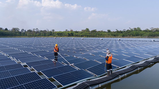 Aerial view from the drone of a team of engineers overseeing the cleaning of solar panels outside the building. Installing solar cells on the roof Solar panels on the roof