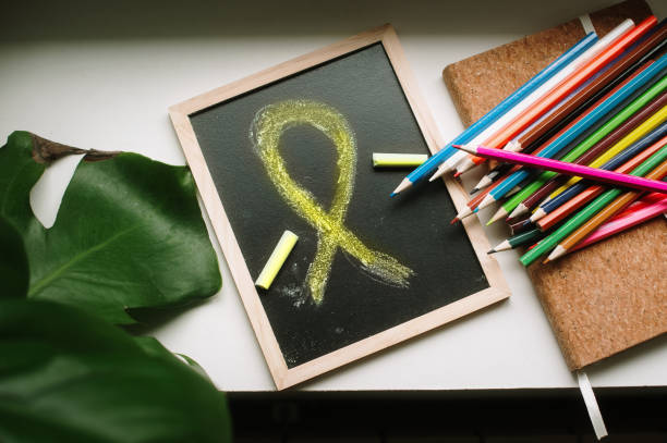 A yellow awareness ribbon drawn on a chalkboard.