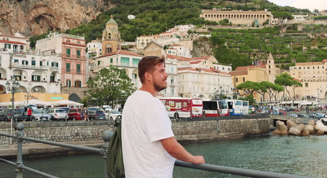 Man with Backpack Walking at Harbour Admiring Scenic View of Amalfi