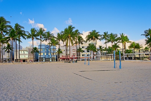 Early morning and the beach volley ball courts are ready for action along Miami's South Beach. The wide south beach offers plenty of room for all kinds of recreation opportunities. The colorful historic art deco district hotels are in the background.