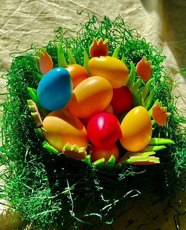 Easter eggs in a basket decorated with grass on a table