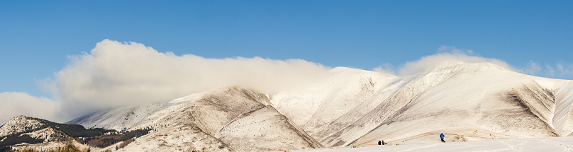 snowy landscape with high rocks in foggy day