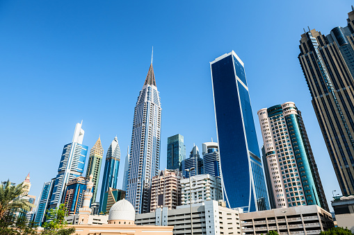 Dubai downtown with modern skyscrapers at sunny day. Dubai, United Arab Emirates. Skyscrapers against the blue sky