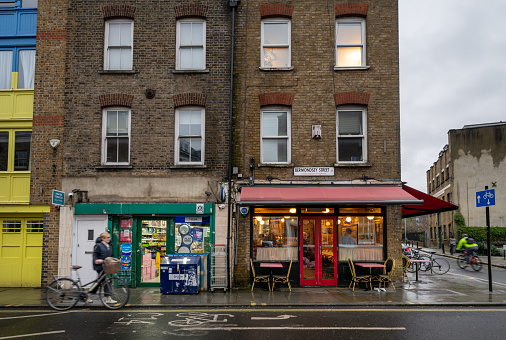 Bermondsey, London, UK: Small shop and restaurants on Bermondsey Street in the London borough of Southwark with two cyclists.