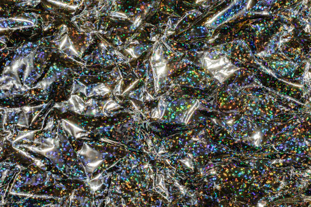 Crinkled plastic wrapping with sparkling details creating an abstract glittering background