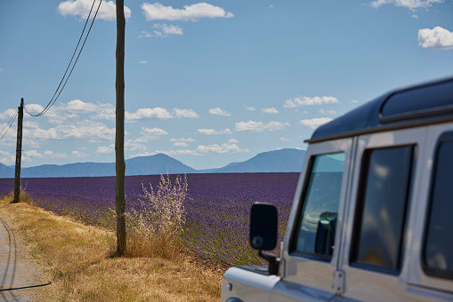 Land rover 4x4 parked next to Lavender field in Provence, France (Plateau de Valensole) on a sunny day in Juni