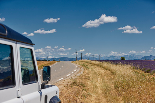 Land rover 4x4 parked next to Lavender field in Provence, France (Plateau de Valensole) on a sunny day in Juni