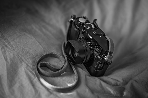 Close up of Black Digital Rangefinder camera in indoor setting.