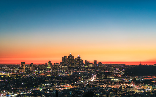 A high angle view over the city of LA, California, with the towers of Downtown illuminated during the blue hour following sunset.