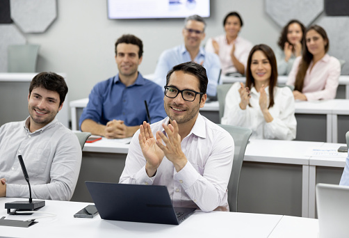 Group of Latin American MBA students applauding in class - education concepts