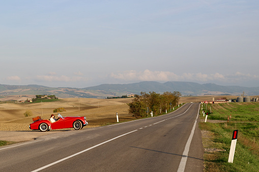 Tuscany, Italy  - 24 October 2022. The couple of people are enjoying their trip. The Triumph TR3 is a British sports car produced between 1955 and 1962 by the Standard Motor Company of Coventry, England.
