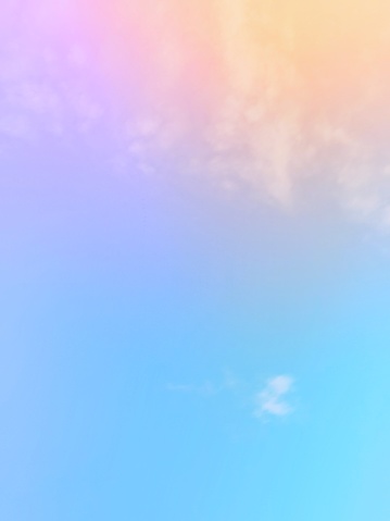 The subtlety of the soft faded clouds  On a pastel gradient rainbow sky background.  Beautiful combinations of pink, orange, red, purple and blue.