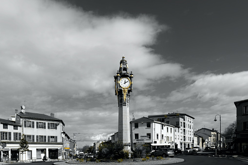 Black an white and yellow picture of the famous clockwork tower roundabout of Tassin la demi lune in France near Lyon.