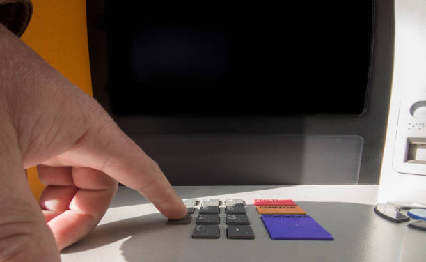 istock Mature man finger pressing password number on ATM machine 2048433003