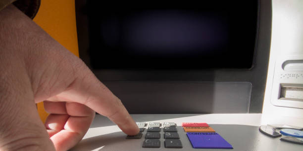 istock Mature man finger pressing password number on ATM machine 2048433006