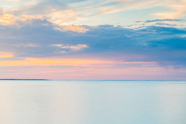 A vast expanse of water, likely a lake, stretches out beneath a sky filled with thick, dark clouds. The scene suggests an impending storm or overcast conditions.