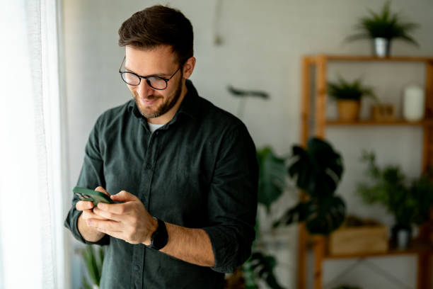 istock Man at home using smart phone for business or pleasure. 2048461997