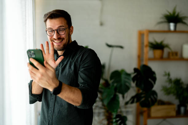 istock Young man on a video call on the mobile phone at home 2048463540