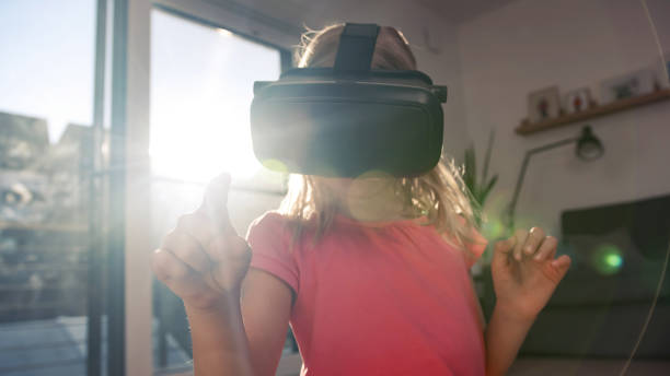 istock Kid with VR goggles looking around and pointing finger 2048475723