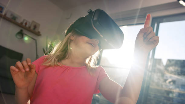 istock Little girl wearing a VR headset, playing at home 2048478904