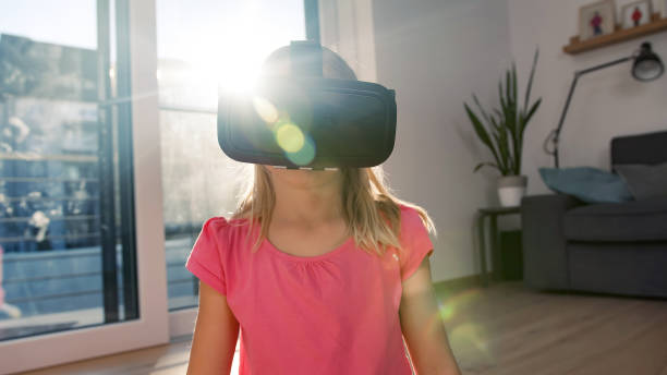 istock Female kid in a VR headset looking around the virtual world 2048479948