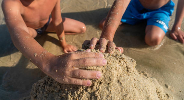 istock Two boys are building a sand tower on the beach. 2048539324