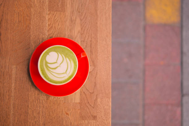 matcha latte in a red color cup on table