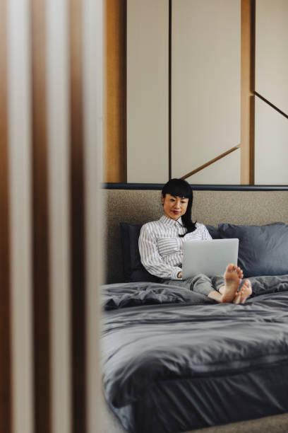 istock Businesswoman using laptop at hotel room 2048546146