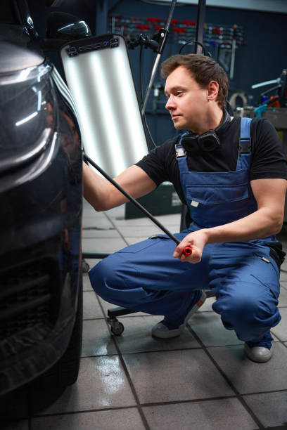 istock Qualified panel-beater is repairing damaged automobile bodywork 2048572244