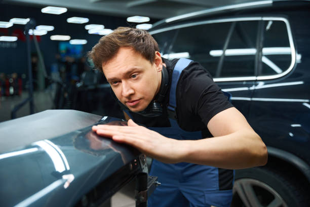 istock Collision repair technician inspecting car body part after dent removal 2048572253