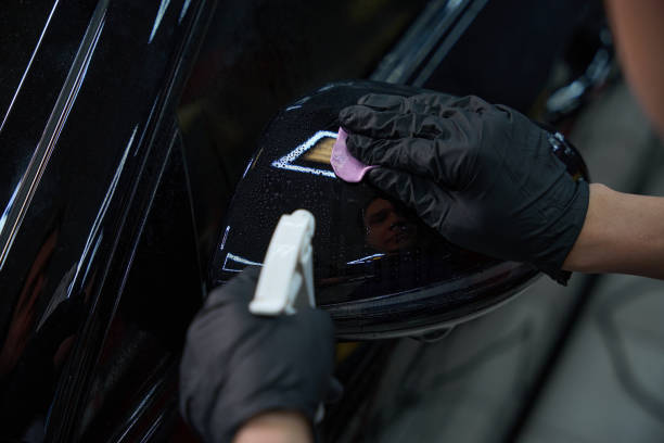 istock Experienced auto detailer is performing vehicle exterior paint decontamination 2048573344