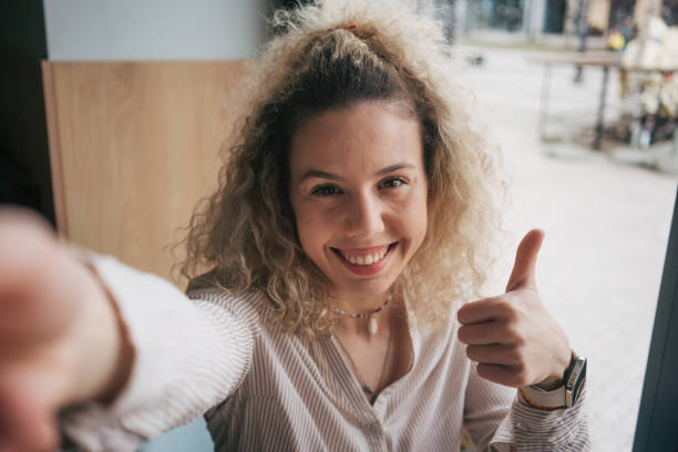 istock Beautiful young woman taking selfie 2048586378