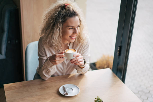 istock Young woman enyojing her coffee 2048594691