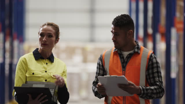 A man and a woman Employees talking in the warehouse