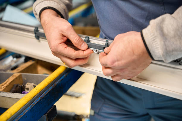 Unrecognizable skilled repairman working in industrial workshop for PVC windows manufacturing
