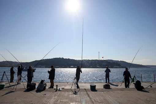 Istanbul,Turkey, September 26, 2012 : Silhouettes, People are fishing near the Istanbul Bosphorus at the sunset