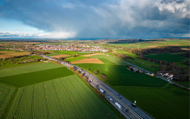 high angle view of the highway between the fields with the rain clouds casting a shadow in germany