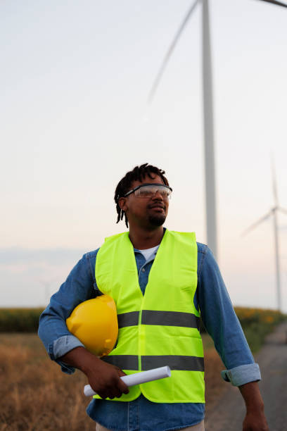 istock Young Engineer wearing uniform ,helmet hold document inspection work in wind turbine farms rotation to generate electricity energy 2048635834