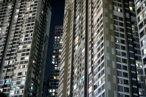 Low angle view of modern skyscrapers at night, towering above