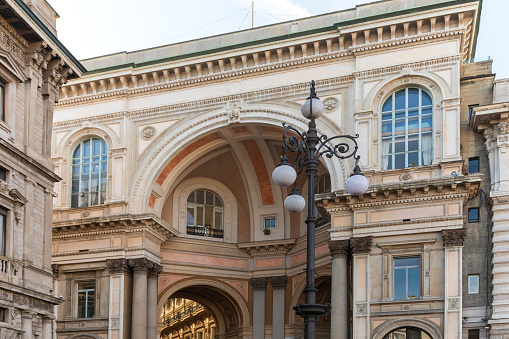 This is an image of a decorative street lamp in front the Galleria Vittorio Emanuele II shopping center in Milan.
