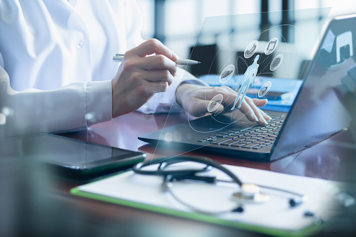 A doctor in the office interacts with the digestive system of a client on a virtual screen.