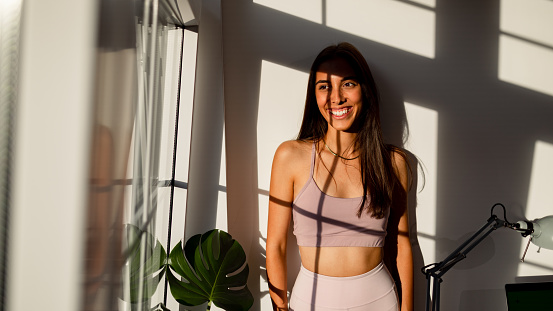 Portrait of a beautiful young woman Brazilian/Hispanic ethnicity, looking through window