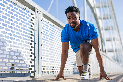 Stretching on a bridge, a young African American man reaches across the physical and metaphorical divides, his practice a powerful reminder of the bridges we build towards better health and understanding through the discipline of fitness